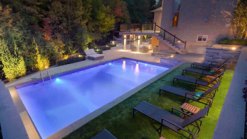 A Pro-Land landscape at dusk — lit pool, terrace and planting